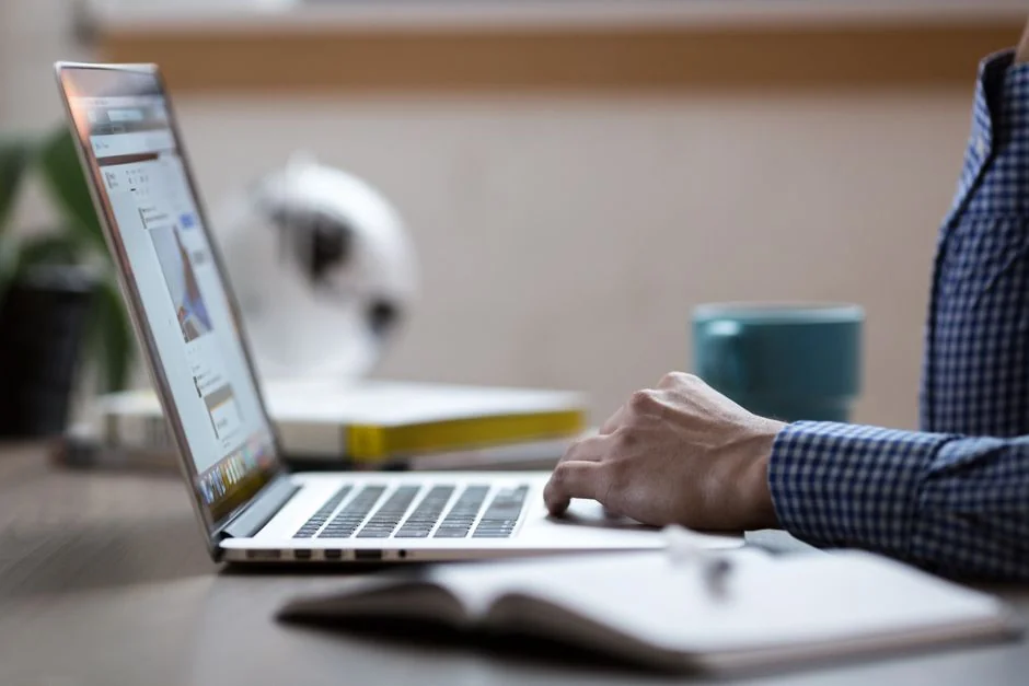 about-us-02 Person analyzing business charts with smartphone and laptop on desk.